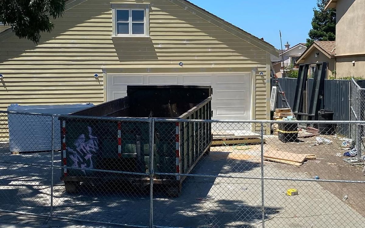 Roll-off container inside the temporary fence of a demolition site