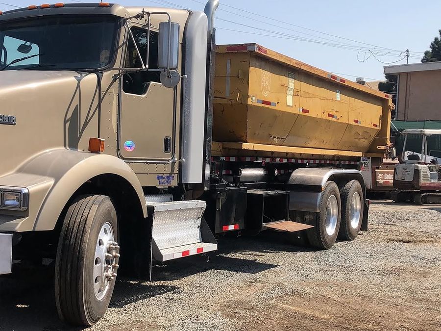Loaded dump truck ready to leave a site alongside an excavator