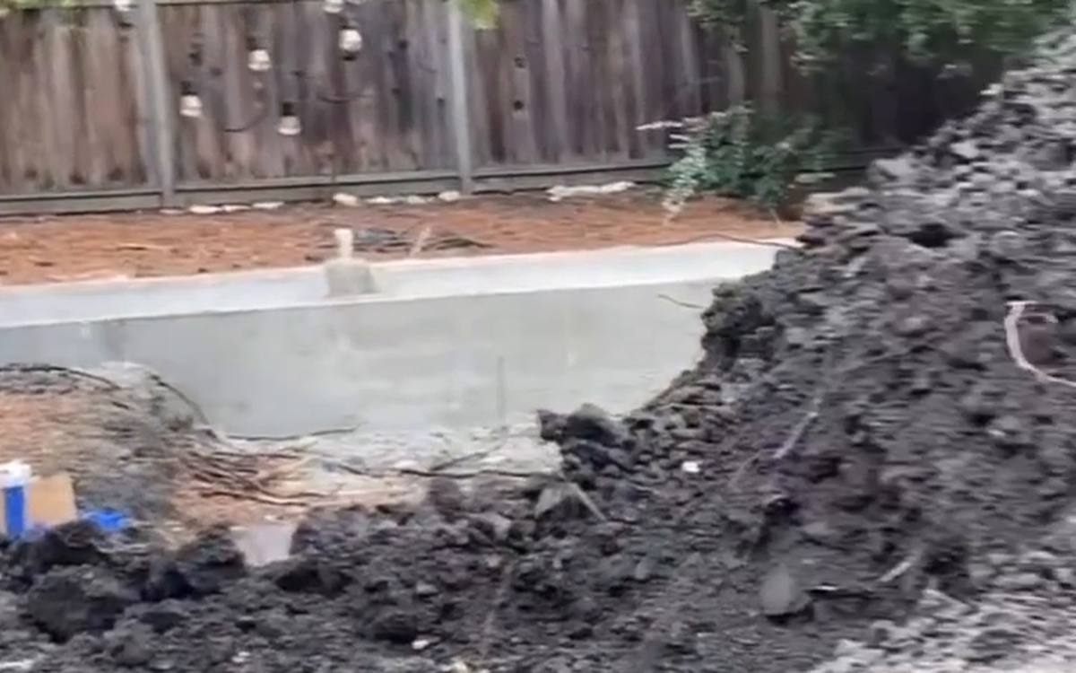 Open cut with excavated soil banked back from the edge