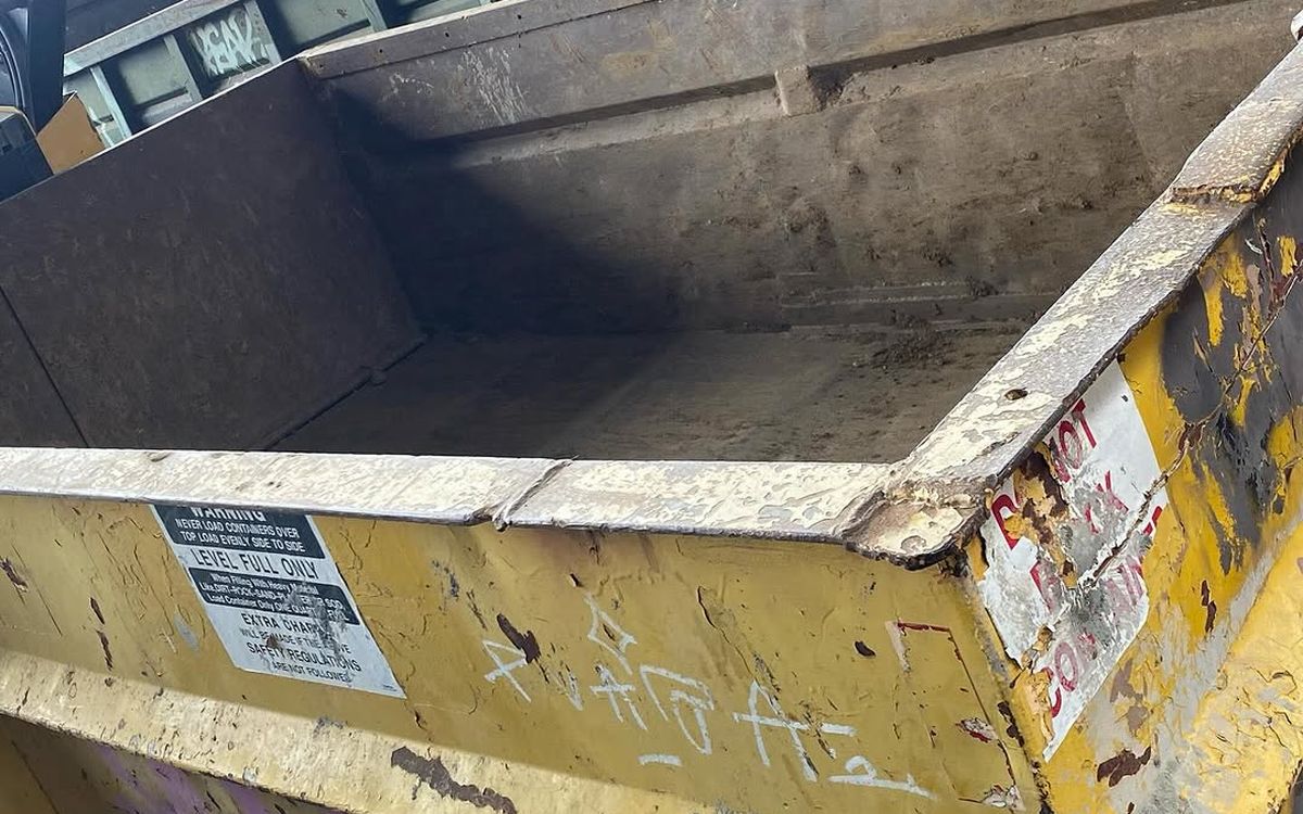 Close-up of a roll-off container showing the level-full only warning label