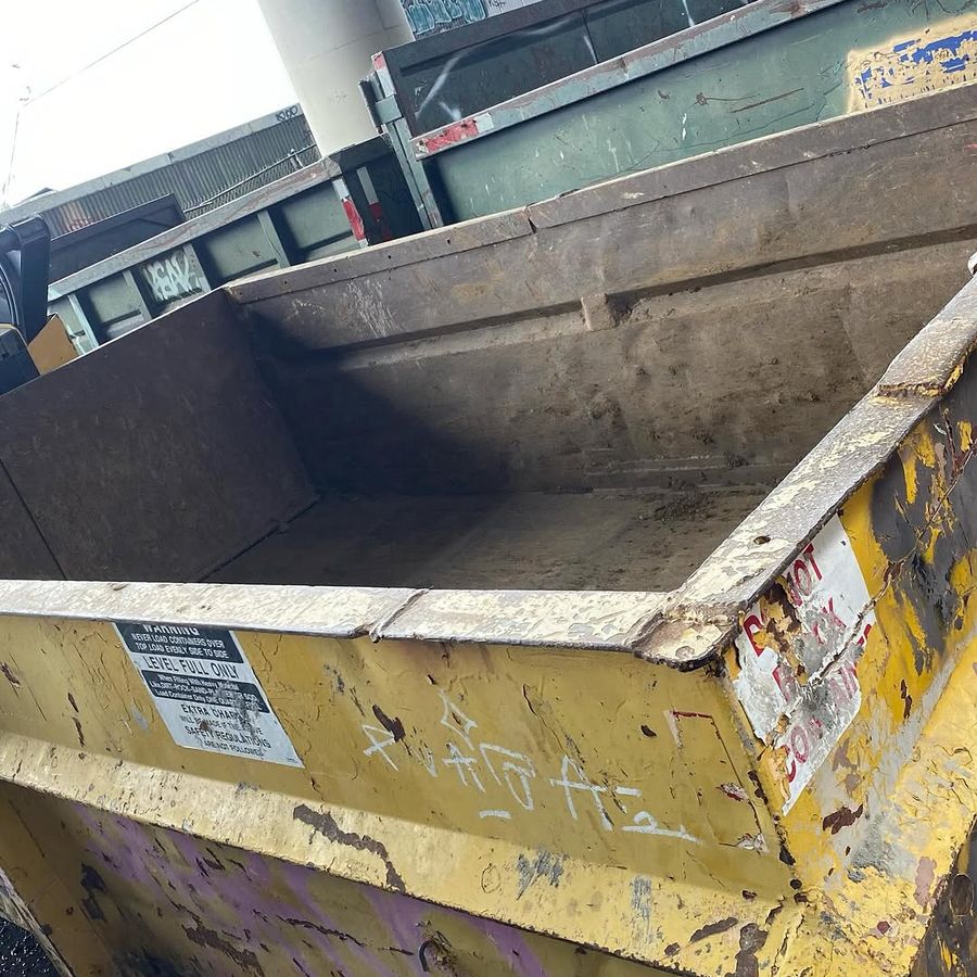 Roll-off containers stacked at the yard showing the level-full warning label