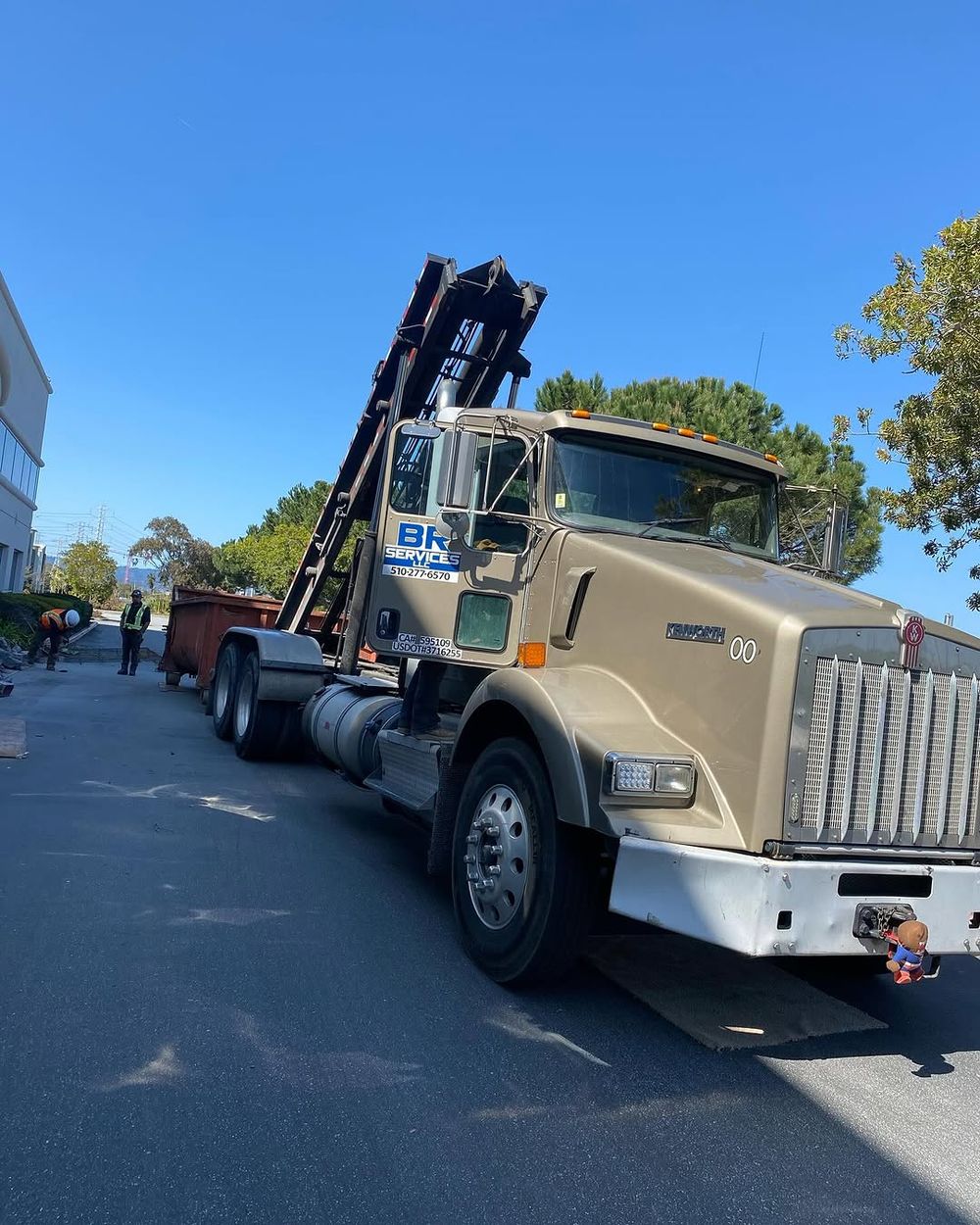 BR Services LLC roll-off truck parked on a street with an empty container loaded behind the cab