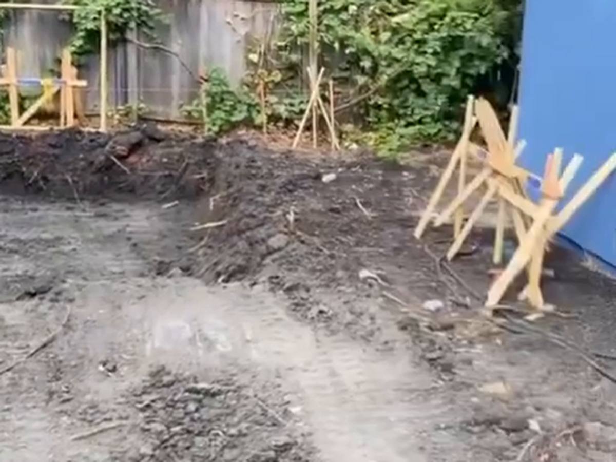 Back yard cut to a consistent grade with layout stakes set along the fence